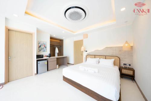 芭堤雅市中心ENNKAI Beachfront Resort Koh Larn的一间带白色床的卧室和一间厨房