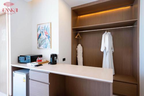 芭堤雅市中心ENNKAI Beachfront Resort Koh Larn的厨房配有书桌和衣柜。