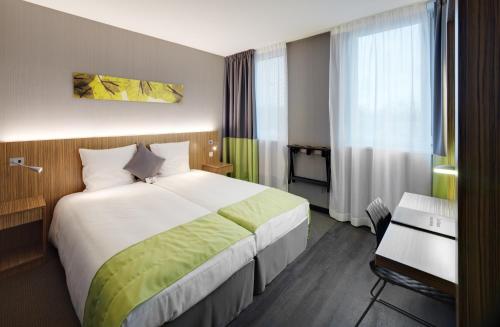 Ruisbroek布鲁塞尔南贝斯特韦斯特酒店 的酒店客房设有一张大床和一张书桌。