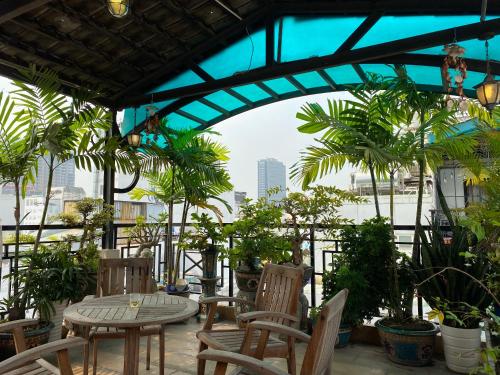 胡志明市金酒店 的一个带桌椅和棕榈树的庭院
