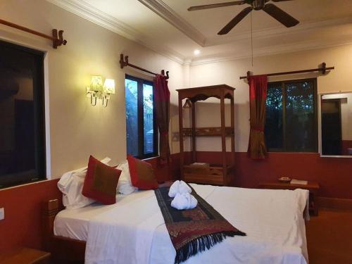 贡布Phoumrumduol Bungalow的一间卧室配有两张床和吊扇