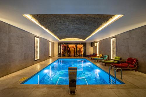 伊斯坦布尔码头时间酒店的一座大型游泳池,位于一栋带客房的建筑内