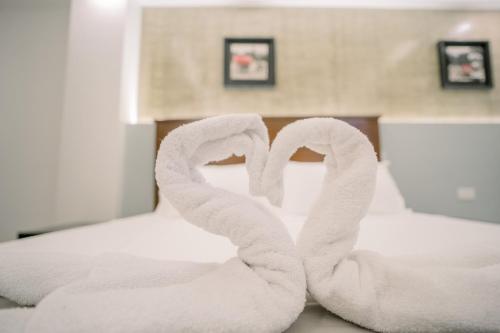 阿拉米诺斯Spotlight Hotel的两条毛巾,形成床上心形
