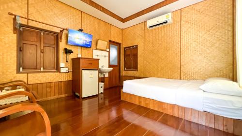 夜功府Baan Siriporn Resort - โรงแรมบ้านศิริพร รีสอร์ท的一间卧室配有一张床和一台电视。