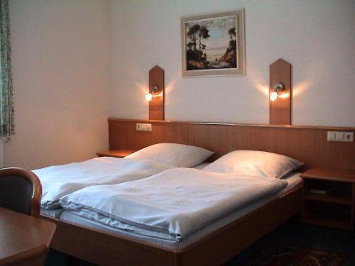 乌尔姆嘉利克劳扎克酒店的一间卧室配有两张床,墙上有两盏灯