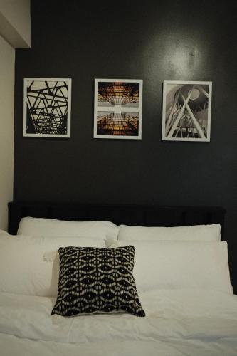宿务Modern Minimalist 1 BR Condo in IT Park的卧室配有三幅墙上的照片和一张床