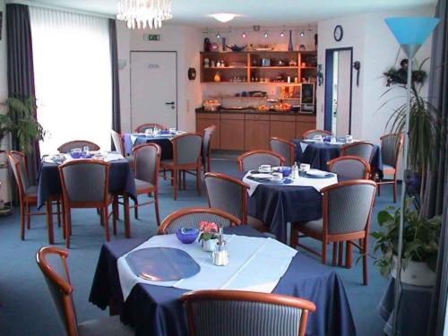 乌尔姆嘉利克劳扎克酒店的一间配备有桌椅及蓝桌布的用餐室
