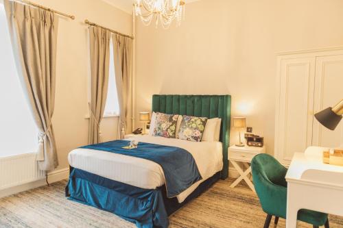 兰卡斯特皇家金斯阿姆酒店的一间卧室配有一张床、一张桌子和一把椅子