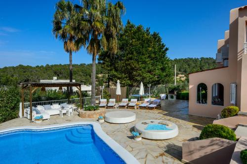 波蒂纳茨Villa Cas Puig - Beach of Portinatx的一个带游泳池和棕榈树的后院