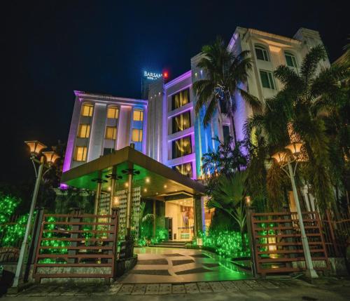 西里古里Barsana Hotel & Resort Siliguri的夜晚有紫色和绿灯的酒店
