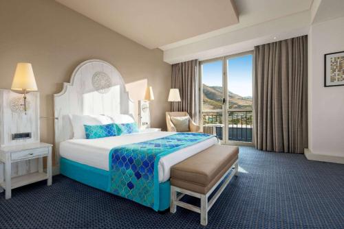 马尔丁Ramada Plaza by Wyndham Mardin的酒店客房设有一张大床和一个阳台。