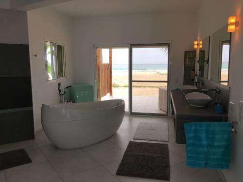 CabeçadasVila Mare - Praia de Chaves frontline的一间带两个盥洗盆和大浴缸的浴室