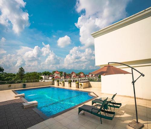 西里古里Barsana Hotel & Resort Siliguri的一座带庭院的建筑的顶部游泳池
