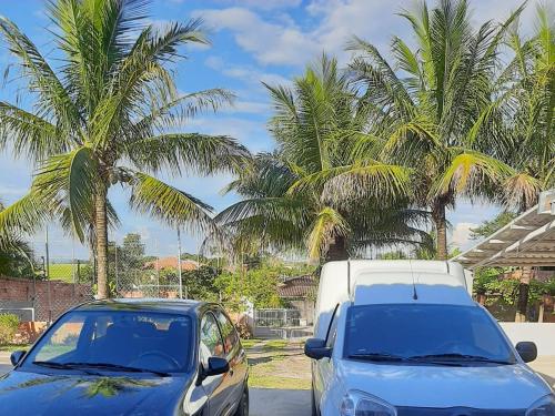 皮拉西卡巴Chacara Oliva的停在棕榈树旁边的蓝色汽车