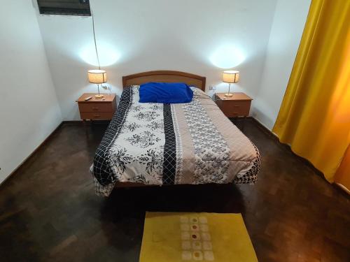 耶尔瓦布埃纳Casa Al pie del Cerro的一间卧室配有一张带2个床头柜和2盏灯的床。