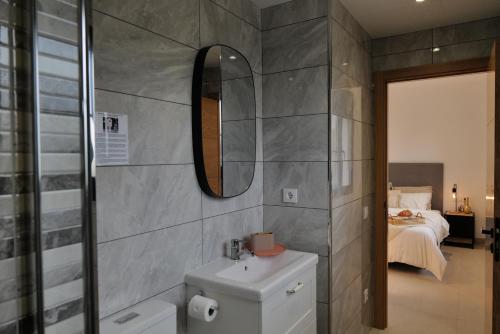 安波拉Villa de lujo EL MIRADOR的一间带水槽和镜子的浴室以及一张床