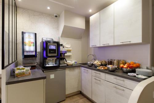 昂蒂布Hôtel de l'Étoile的厨房配有咖啡机和水果台面