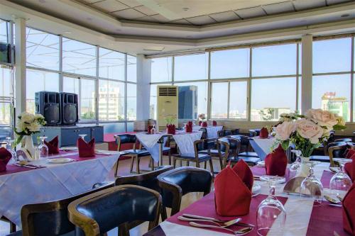 达卡Hotel Shuktara Dhaka的用餐室配有桌椅和红色餐巾