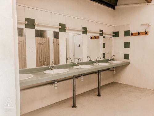 拉卡沃Lodg'ing Nature Camp Dordogne的配有4个盥洗盆和镜子的公共浴室