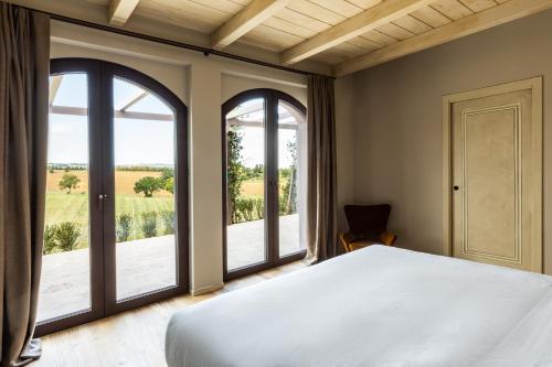 San NicolòCountry House Oliveto sul Lago的一间卧室设有一张床和两个窗户。