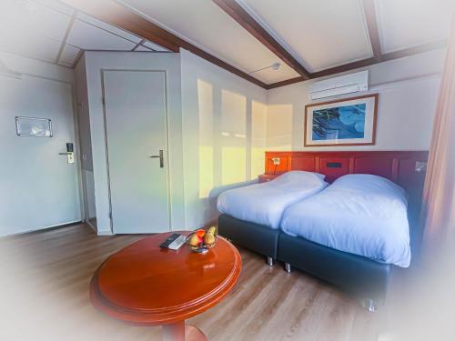 代尔夫宰尔推进器酒店的一间卧室配有一张床和一张桌子