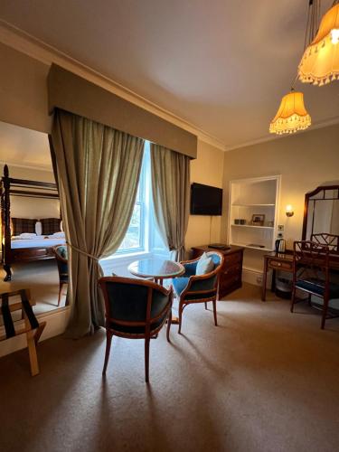 Edinbain格瑞斯奥尼斯屋酒店的配有一张床和一张桌子及椅子的房间