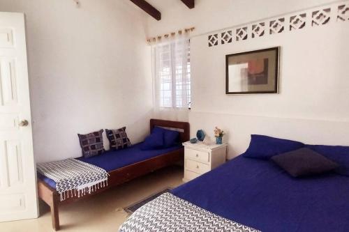 通苏帕Casa Albatros (Playa-Esmeraldas)的一间卧室配有两张蓝色床单