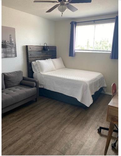 基林Cozy5star的一间卧室配有一张床、一张沙发和一个窗口