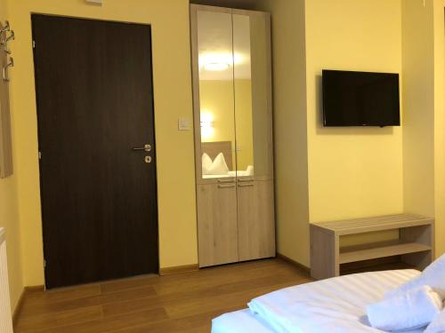 蒂米什瓦拉Vila Toscana的一间卧室设有一扇门,配有镜子和电视