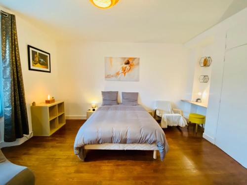 圣纳泽尔Le Joly Cocon-Proche mer-wifi-fibre的卧室配有一张床和一张桌子及椅子