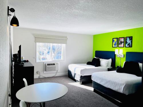 尤金Signature Inn Eugene的酒店客房设有两张床和一张桌子。