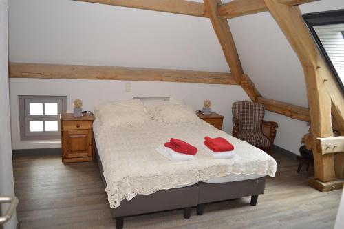 泽兰省Herberg d'n Driesprong的一间卧室配有一张带两个红色毛巾的床