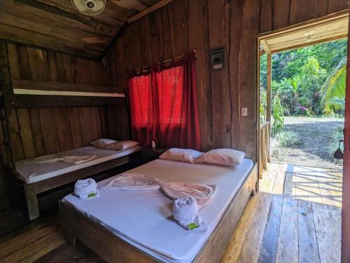 德雷克Citronela Lodge Corcovado的木间设有两张床,设有窗户