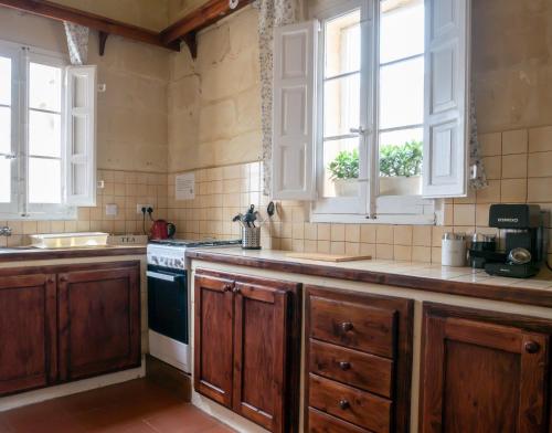 沙拉Il Gnejna的厨房配有木制橱柜、水槽和窗户。