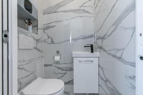 维勒蒙布勒MBA Splendide Appart - Le Raincy - Banlieue Paris的浴室配有白色卫生间和大理石墙。