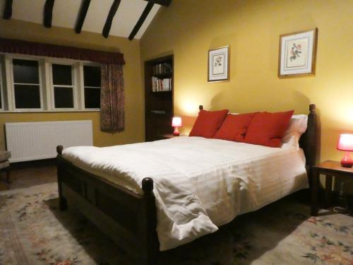 奥尔德姆Hawkyard's Cottage的一间卧室配有一张带橙色枕头的大床