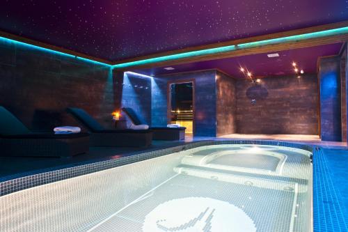 莱热金羚羊酒店的紫色照明的客房内的热水浴池