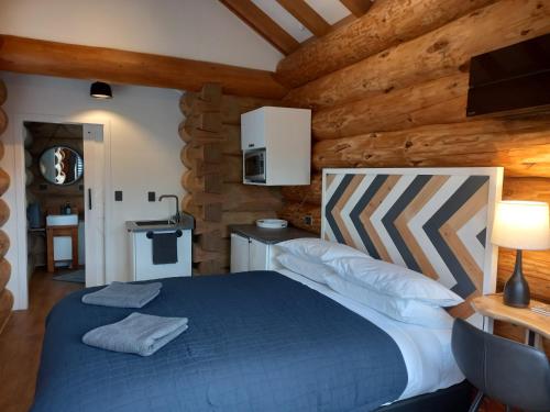特威泽尔The Cabin的小木屋内一间卧室,配有一张蓝色的床