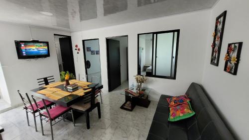 比亚维森西奥Apartamentos El Caudal, Villavicencio的客厅设有餐桌和沙发
