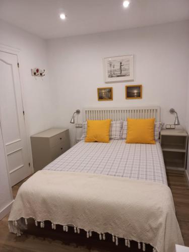 希洪Rosario 14 Cimavilla的一间卧室配有一张带两个黄色枕头的床
