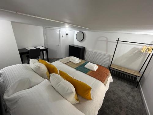 曼彻斯特Airport Hideaway的卧室配有一张带黄色枕头的大型白色床。