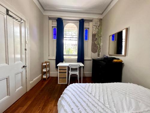 悉尼Peaceful Haven的一间卧室配有一张床、一张书桌和一个窗户。