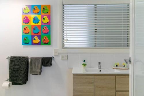 扬巴BEACHED @ YAMBA (water views, dog friendly, air con)的一间带水槽和窗户的浴室
