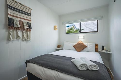 圣海伦斯圣海伦斯四大假日公园的一间卧室配有一张床,上面有两条毛巾