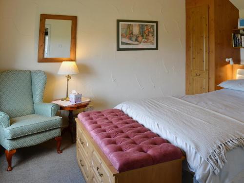 EdlinghamGarden Cottage的一间卧室配有一张床、一把椅子和镜子