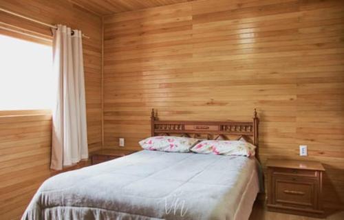 圣若阿金Casa do Guiga的一间卧室设有一张床和木墙