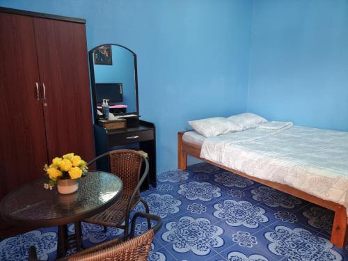 清莱หอพักโชคอนันต์的一间卧室配有桌子、床和桌椅