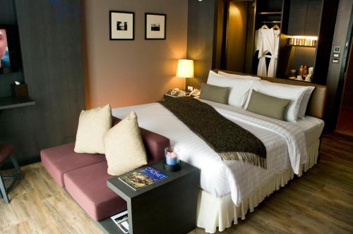 芭堤雅市中心AYA Boutique Hotel Pattaya - SHA Plus的酒店客房设有一张大床和一张沙发。