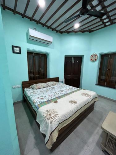 加尔各答Teakwood Suite - Nokha House的一间卧室配有一张带蓝色墙壁的大床
