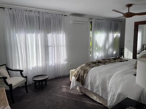 科夫斯港Jetty beach shack的一间卧室配有一张床、一把椅子和窗户。